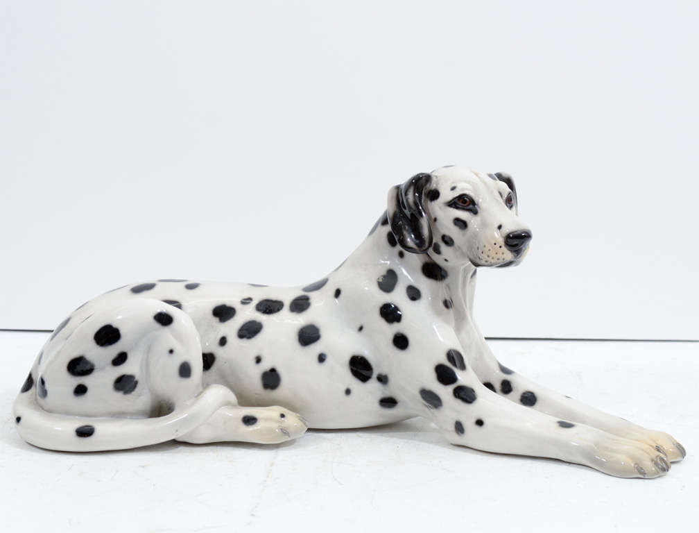 A vintage Italian ceramic sculpture of a black and white spotted Dalmatian dog; ideal for desks or tabletops. Signed and numbered on the bottom. Some yellowing to paws.