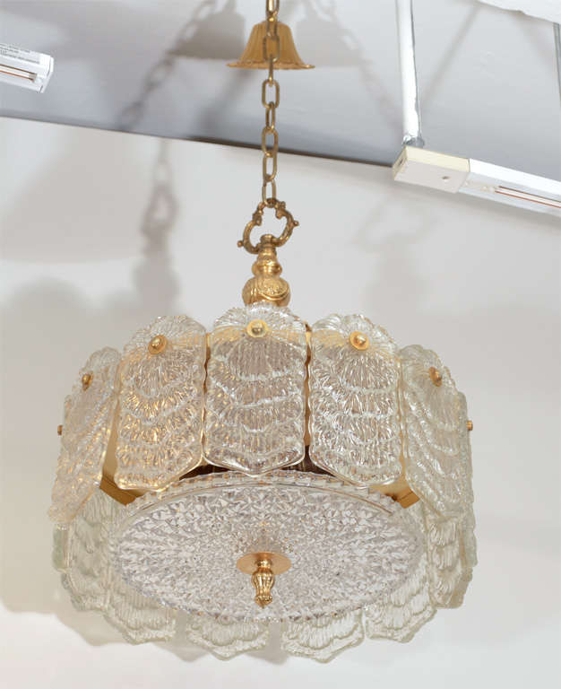 Circular clear, textured cast-glass that is well formed and heavy, chandelier with polished brass detailing by Camer.

