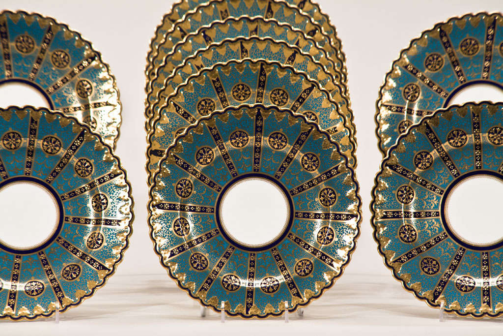 These 12 plates are a show stopper with a very unusual pattern in the Arts and Crafts style. With pie-crust shaped rims, these have a William Morris feel to the thick enamel and raised paste gold. The teal ground contrasts beautifully with the