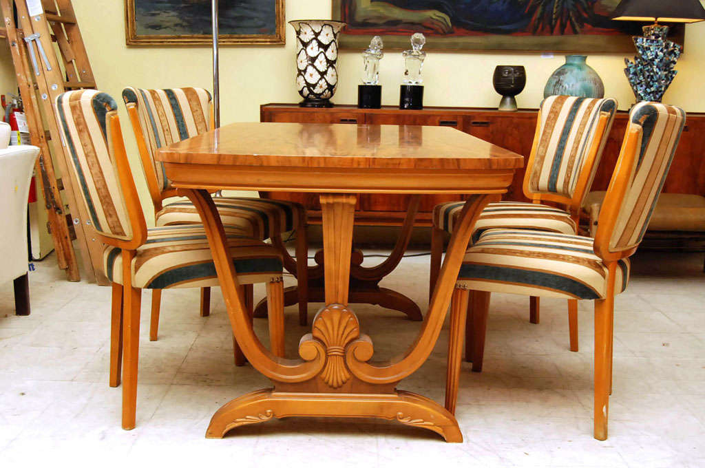 Art Deco dining set, table and four chairs in fruitwood, the table having lyre-shaped base, the chairs with reeded legs,  uphoslstered in a green and gold striped fabric