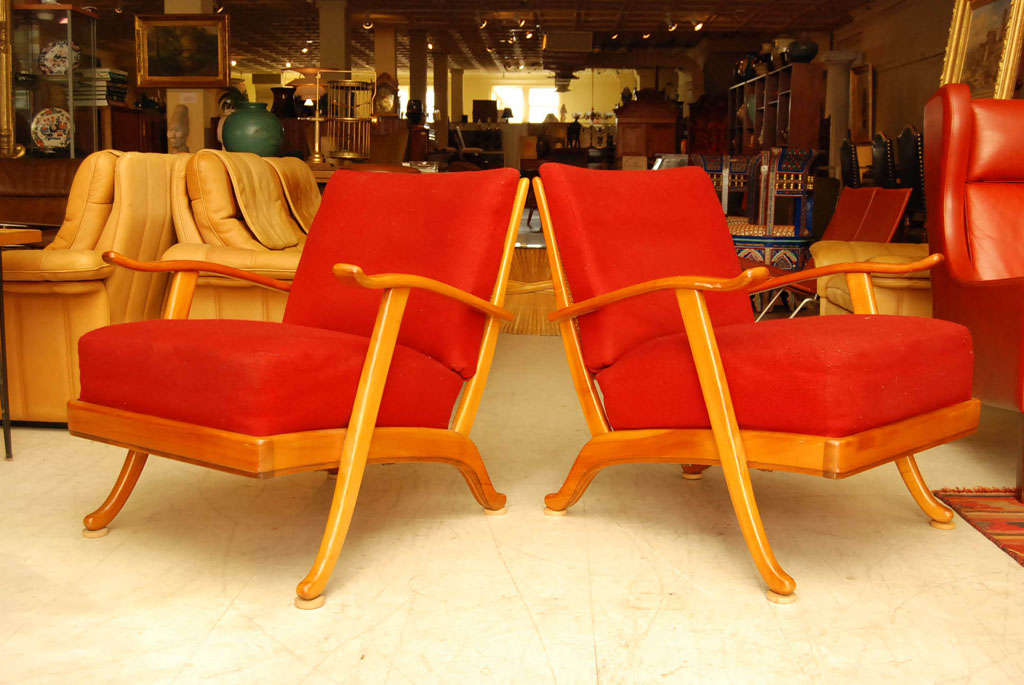 Pair of lounge chairs with fruitwood frames with caned backs and red upholstered cushions