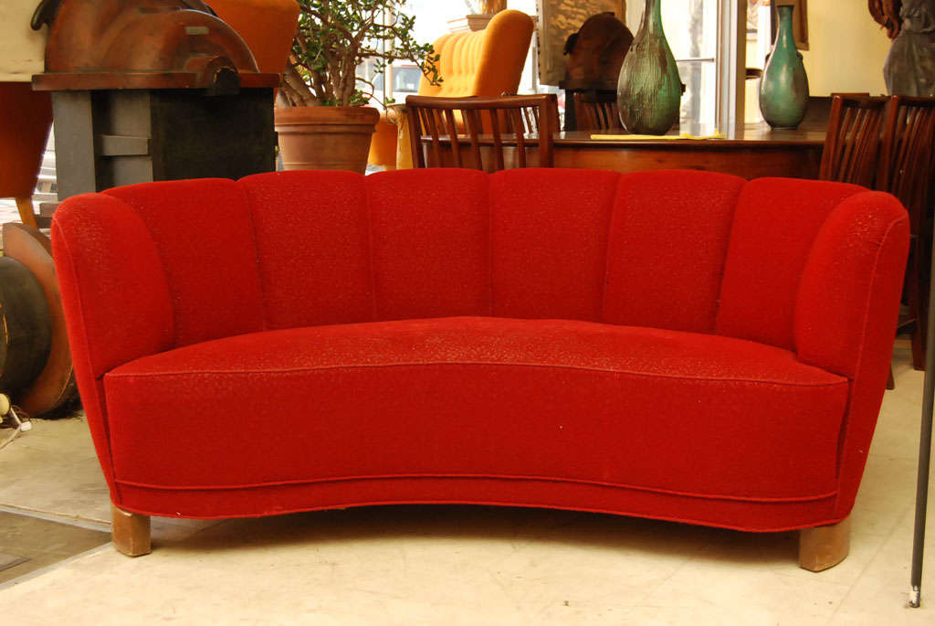 Banana-shaped sofa with upholstered in red with channelled back and curved beechwood feet