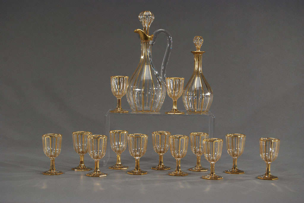 A suite of gorgeous wine goblets, made by Baccarat with panel cutting and elegant, gilded decoration. The octagonal foot, polished pontils and panel cut sides give these goblets a nice weight and the decorative gilding makes a dramatic statement.