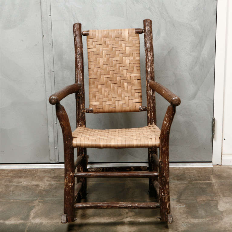This is a great Old Hickory type rocking chair with arms. The seat and back have recently been renewed in the original woven  split oak method. Just the type item for that rustic setting. Jefferson West Antiques offer a selection of seating,