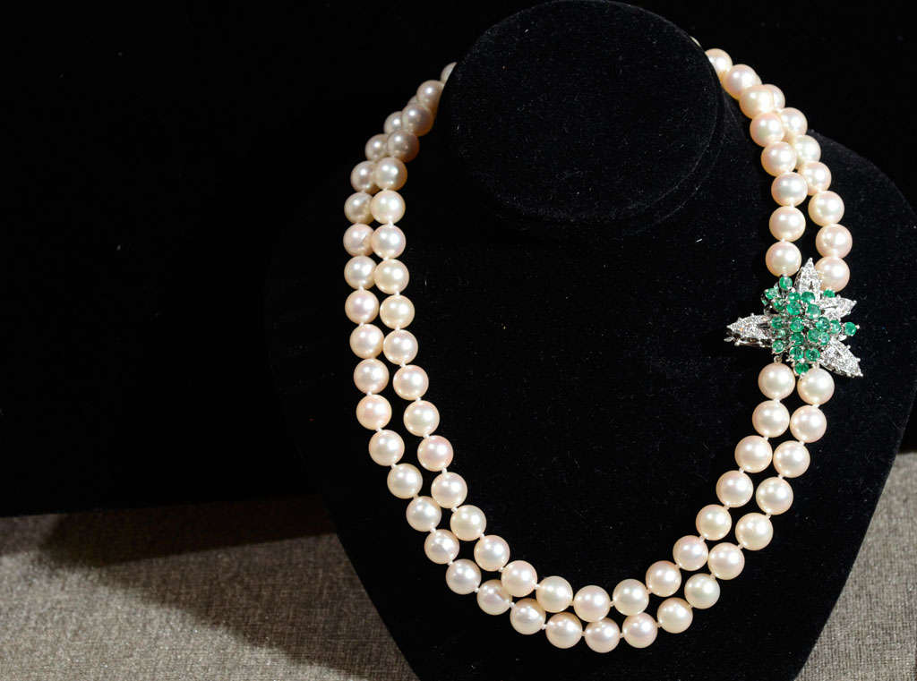 This stunning double strand necklace is of 8.5mm Cultured pearls with a clasp composed of emeralds and diamonds, set in 14k white gold.Thge pearls are a beautifully matched creme luster. The diamonds are full cut stones and the emeralds are a really