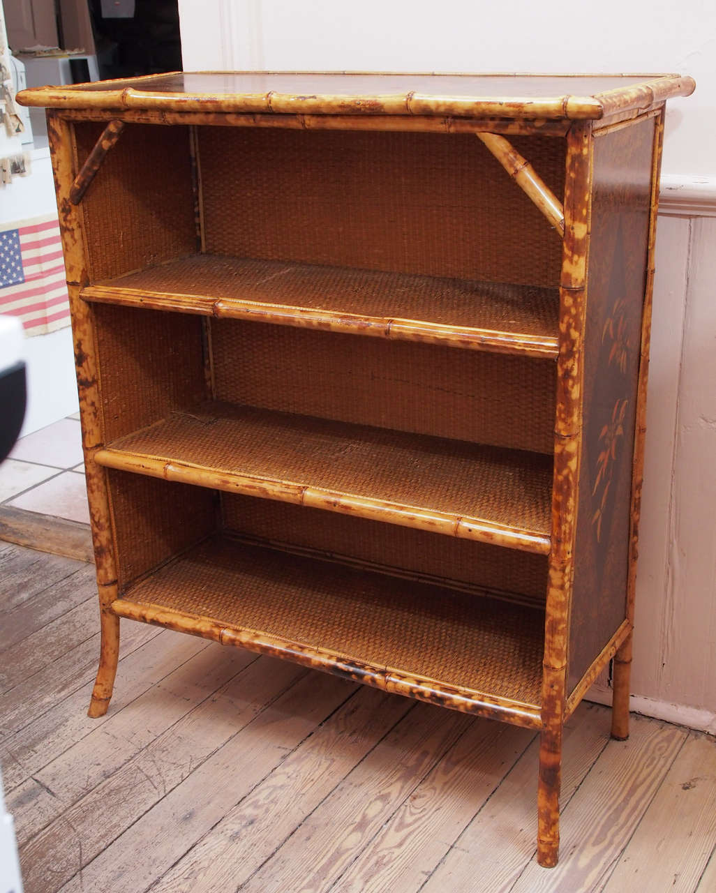 The frame of this vintage bookcase consist of bamboo with painted birds and leaves in a chinoisserie style on both the top as well as the sides.