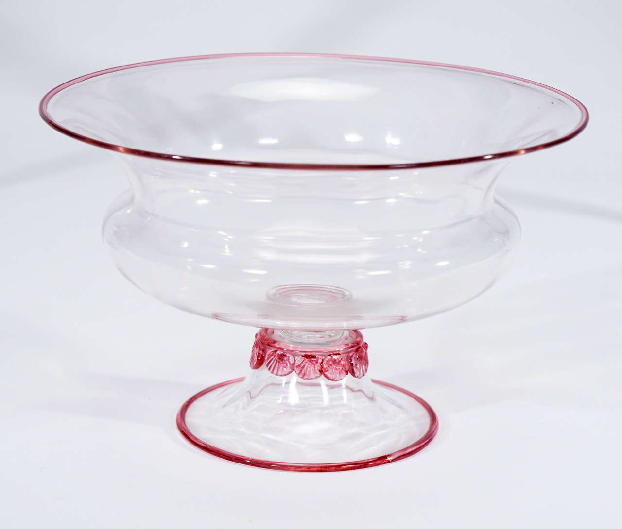 A rare and elegant three-piece Steuben centerpiece set consists of a large footed center bowl and a pair of matching candlesticks. The clear body is embellished with applied 