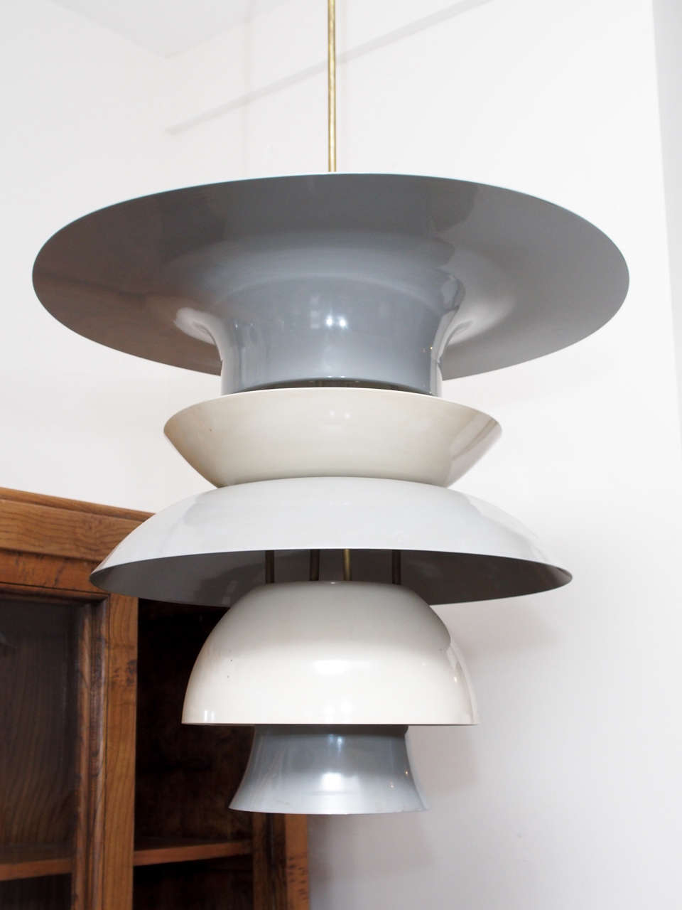 Two single-light pendants in spun metal lacquered gray and ivory; brass mounts;
Measurements are for fixture only; brass stem adds 32