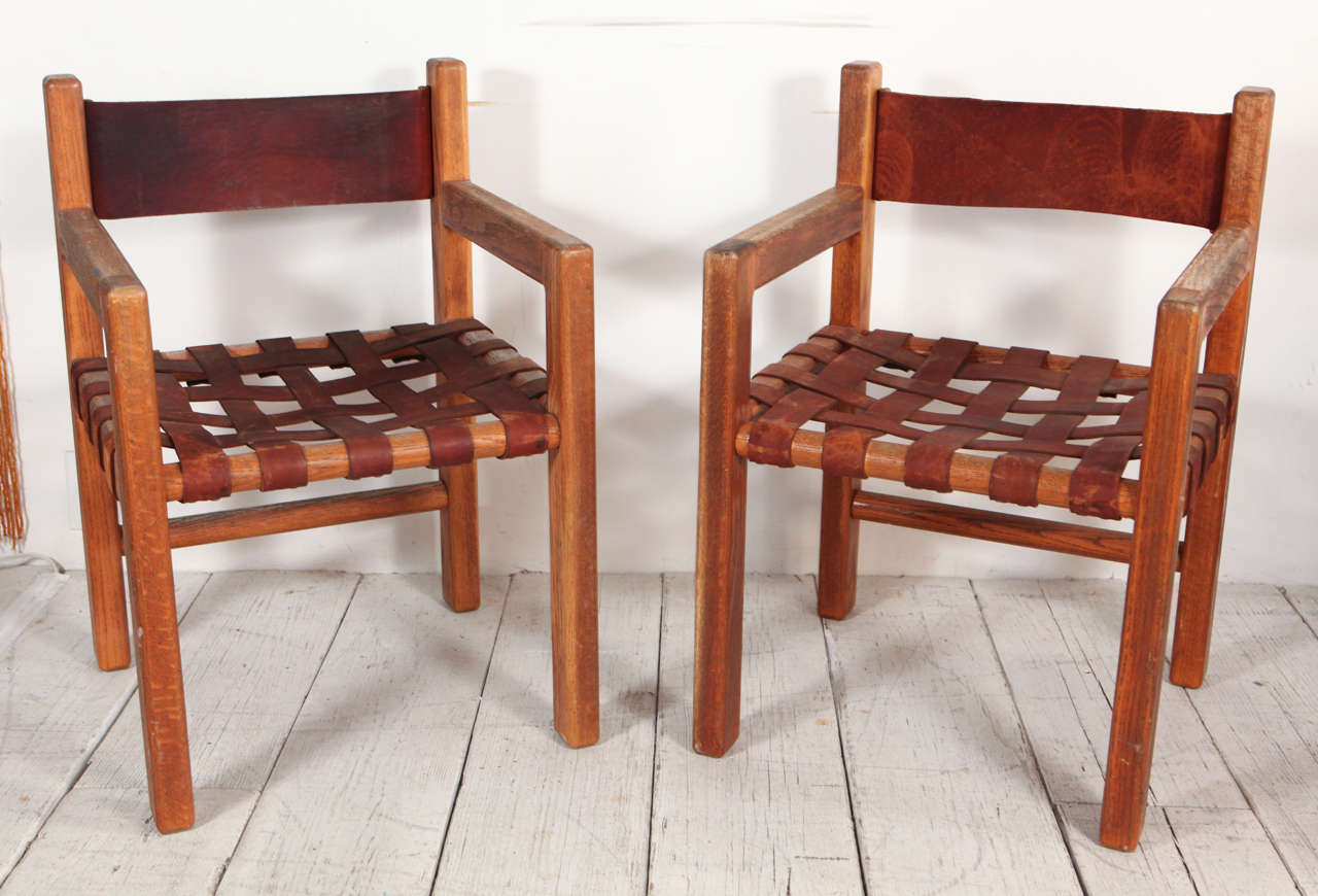 Six arm chairs with woven leather seat and leather backs. May be broken up in pairs.