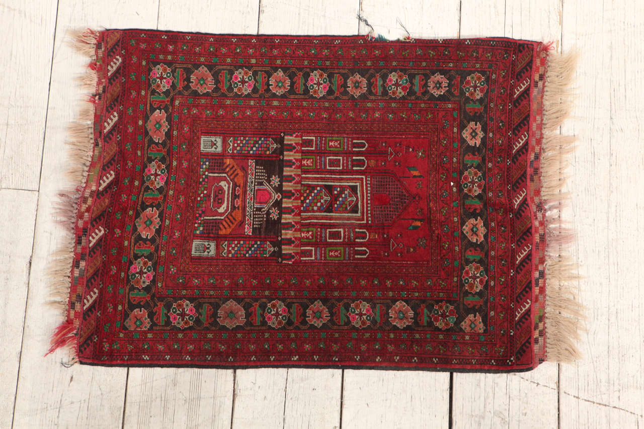 Small woven rug with temple like detail.