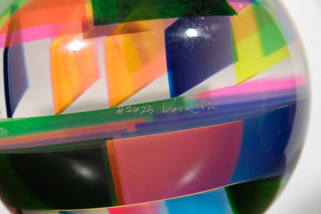 Solid sphere of lucite with intersecting inner planes of color.   Signed and numbered (#2023).