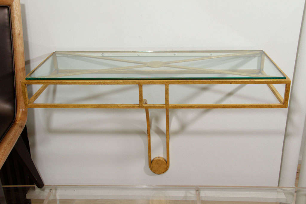 Wall hanging console by Jean Royere, gilt metal frame with glass top.