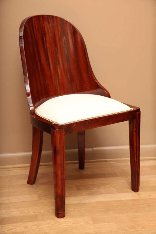 A set of 6 Art Deco dining chairs with beautiful curved walnut backs and upholstered seats trimmed with nailheads. In the manner of J. E. Ruhlmann.