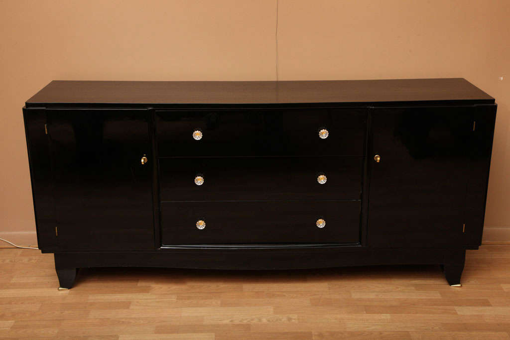 Chic Art Deco sideboard in black lacquer with original glass pulls. Two side doors reveal shelving, center has four drawers.