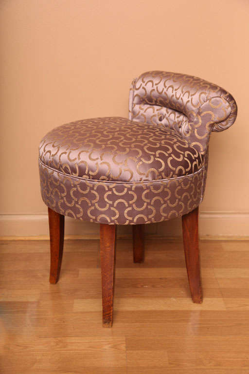 Sculptural upholstered rolled back with decorative buttons and round seat.