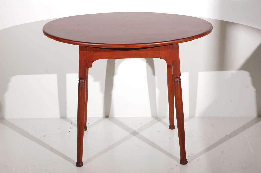 This 18th century refinished Queen Anne side table has great form and hand-carved legs and pad feet. The cut-out skirt is all hand-carved and wood peg construction throughout. The condition is very good and this cherry table has a red wash stain.