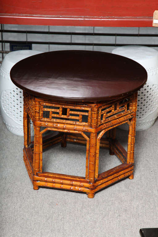 A well-made 19th century bamboo hexagonal side or coffee table with soft black lacquered circular wooden top. This exotic 19th century Chinese side table displays an exquisite bamboo base and a round black lacquered wooden top. The top is nicely