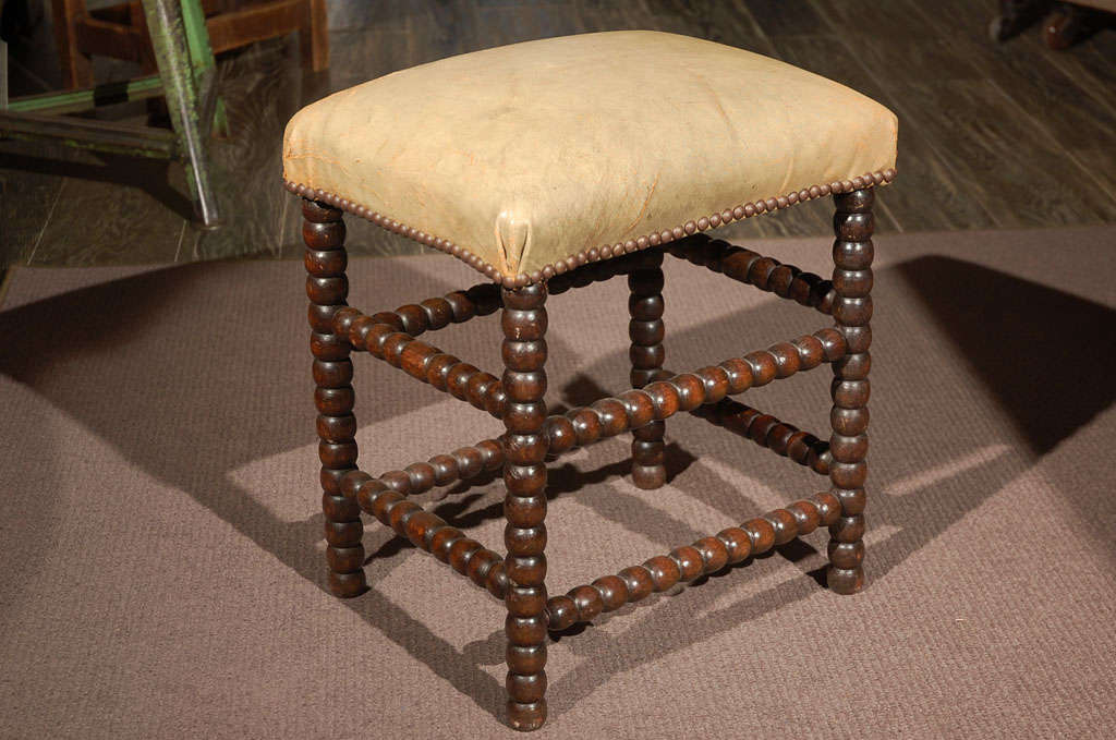 A stud trim seat bobbin stool of petite proportions with double stretchers