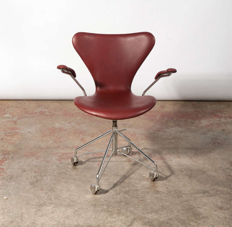 Office chair, 'Seven' with armrests, in molded plywood upholstered with leather, swivel four-star chromed steel wheels, Height adjustable. Designed in 1955. Produced by Fritz Hansen.