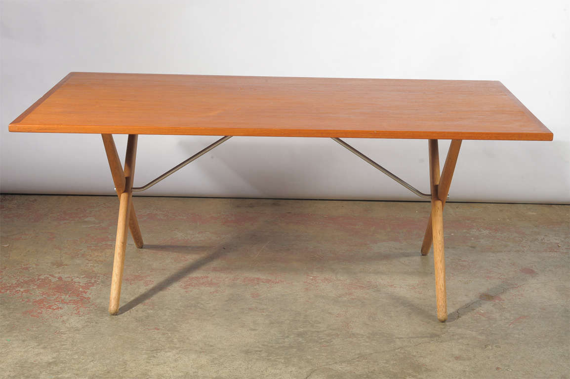 Dining table with solid oak cross-leg base and brass cross bars; teak tabletop. Designed in 1955. Produced by Andr. Tuck, stamped accordingly.