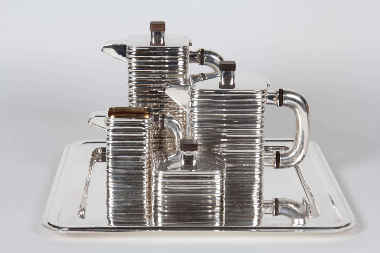 AMERICAN ART DECO

Sterling Coffee and tea set on silverplate tray c. 1935

Sterling Coffee and Tea Set: Sterling with exotic wood finials and finials
Marks:  925, Sterling

Tray: Silverplated brass
Marks: Silverplated On Brass, PM Italy,