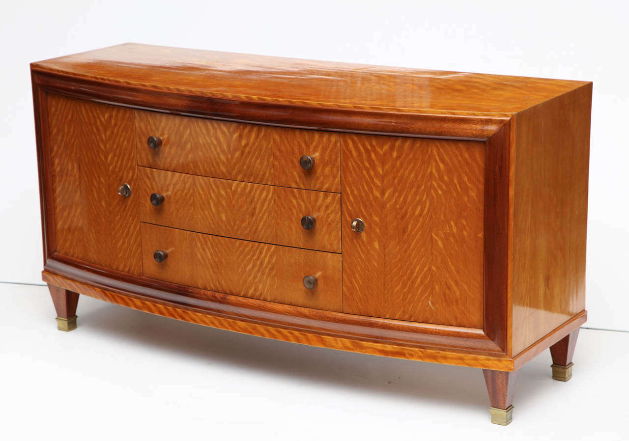 Art Deco bow front cabinet in mahogany and blond mahogany with brass sabots.