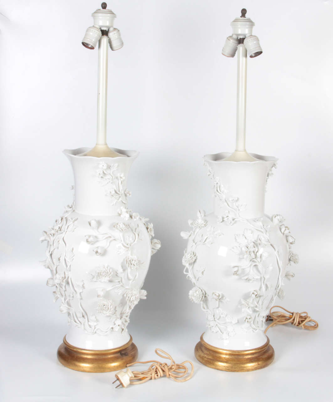 An unusual pair of antique Blanc de Chine porcelain vases mounted as lamps with giltwood bases. Each baluster shaped vase is embellished in relief with porcelain flowers and leaves, mid-1800s.

An excellent addition to a 20th century interior.