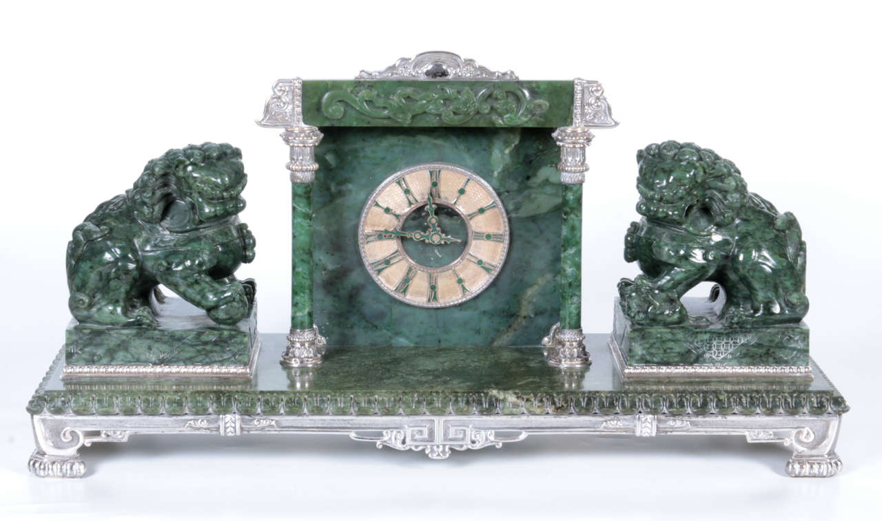 Silvered bronze-mounted Chinese, spinach jade portico mantel cock with Foo dogs. Retailed by Yamanaka & Co., New York, early 1900s. 

With Roman dial within an architectural surround flanked by Buddhist lions on a plinth base, the underside