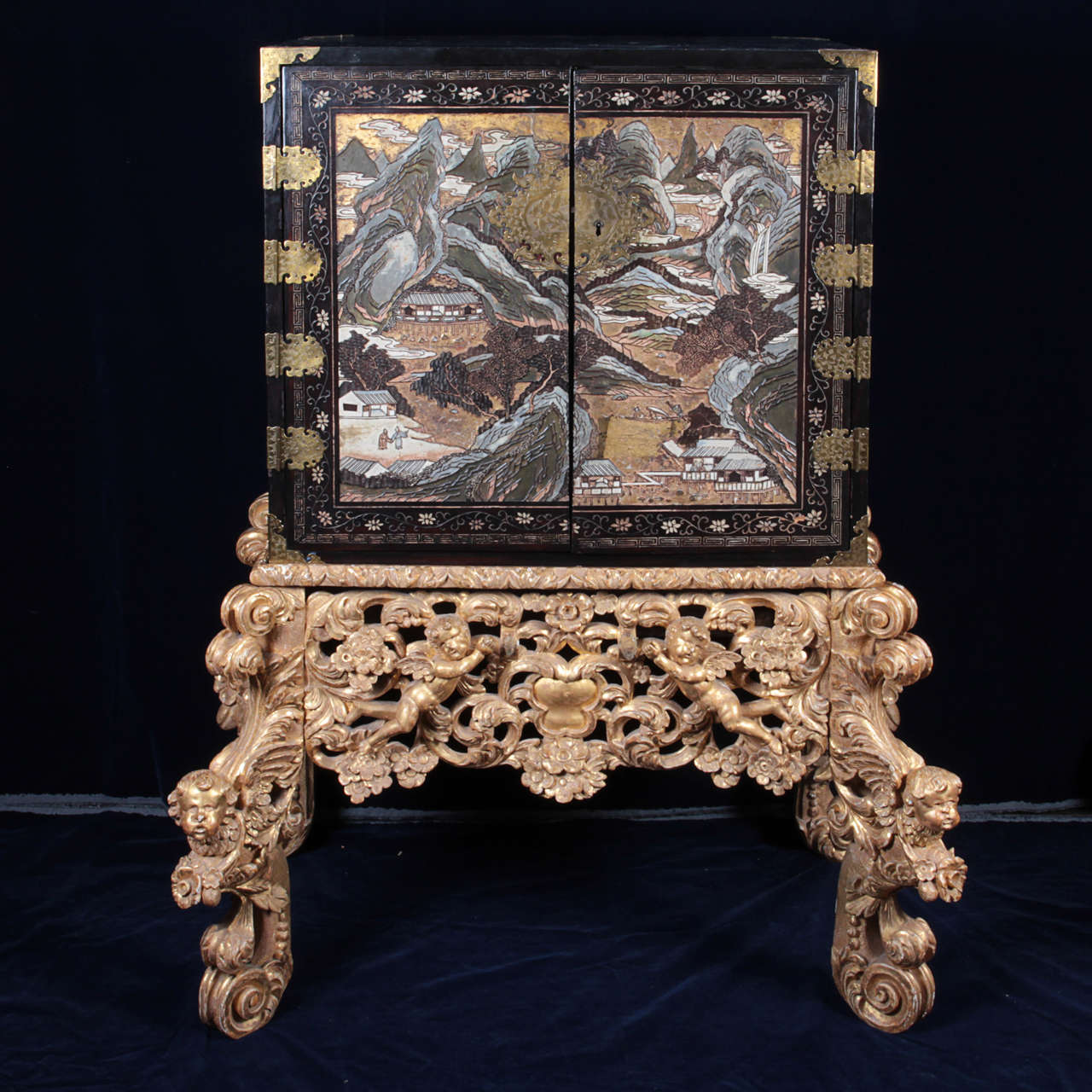 An unusual Chinese carved coromandel chest from the late 1600s-early 1700s on a 18th century English giltwood carved base. The chest opens to unveil beautifully decorated compartments that smoothly slide out. Each of the compartments has an
