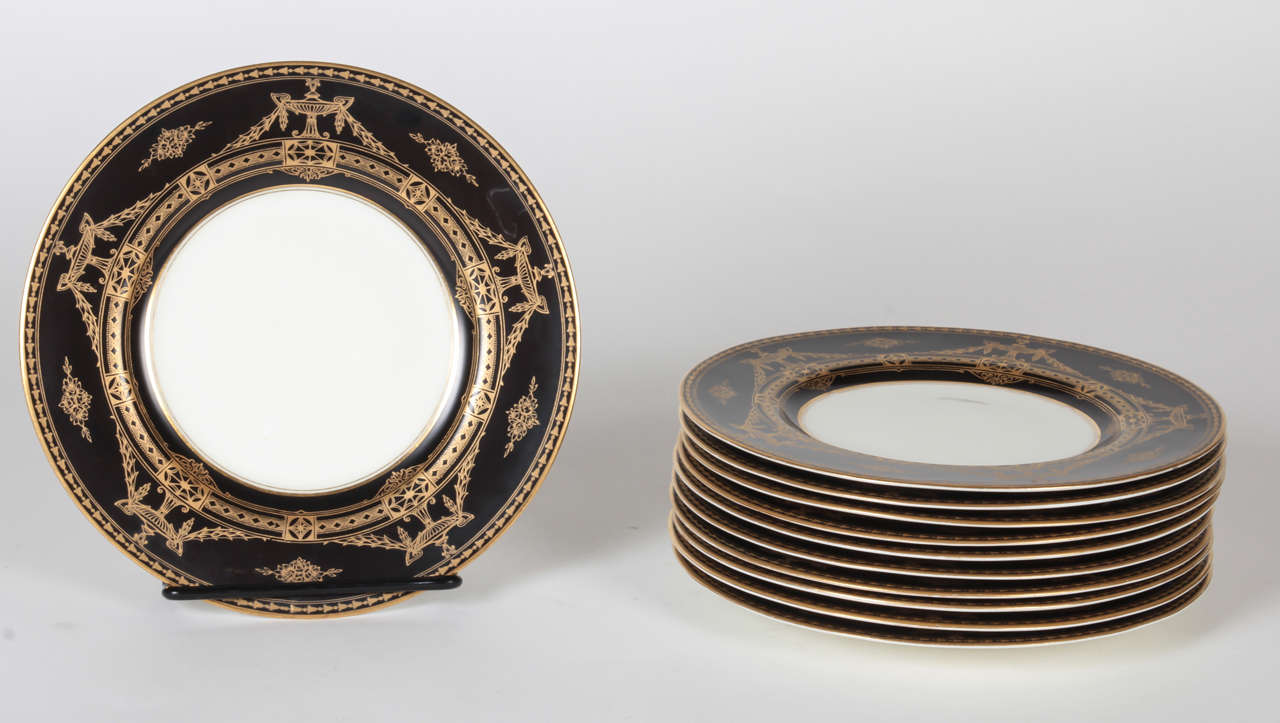 Royal Worcester, set of 11 dessert plates with neoclassical design, gilt foliate urn and swag on a black background.