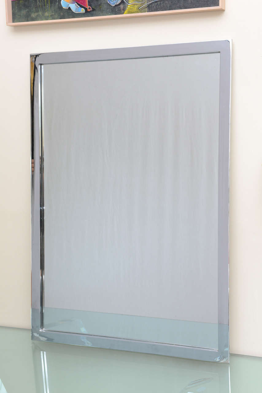 Stunning Mid-Century Modern rectangular wall mirror in chromed steel. 
Can be hung landscape or portrait style. 
This mirror is a highlight in any room.