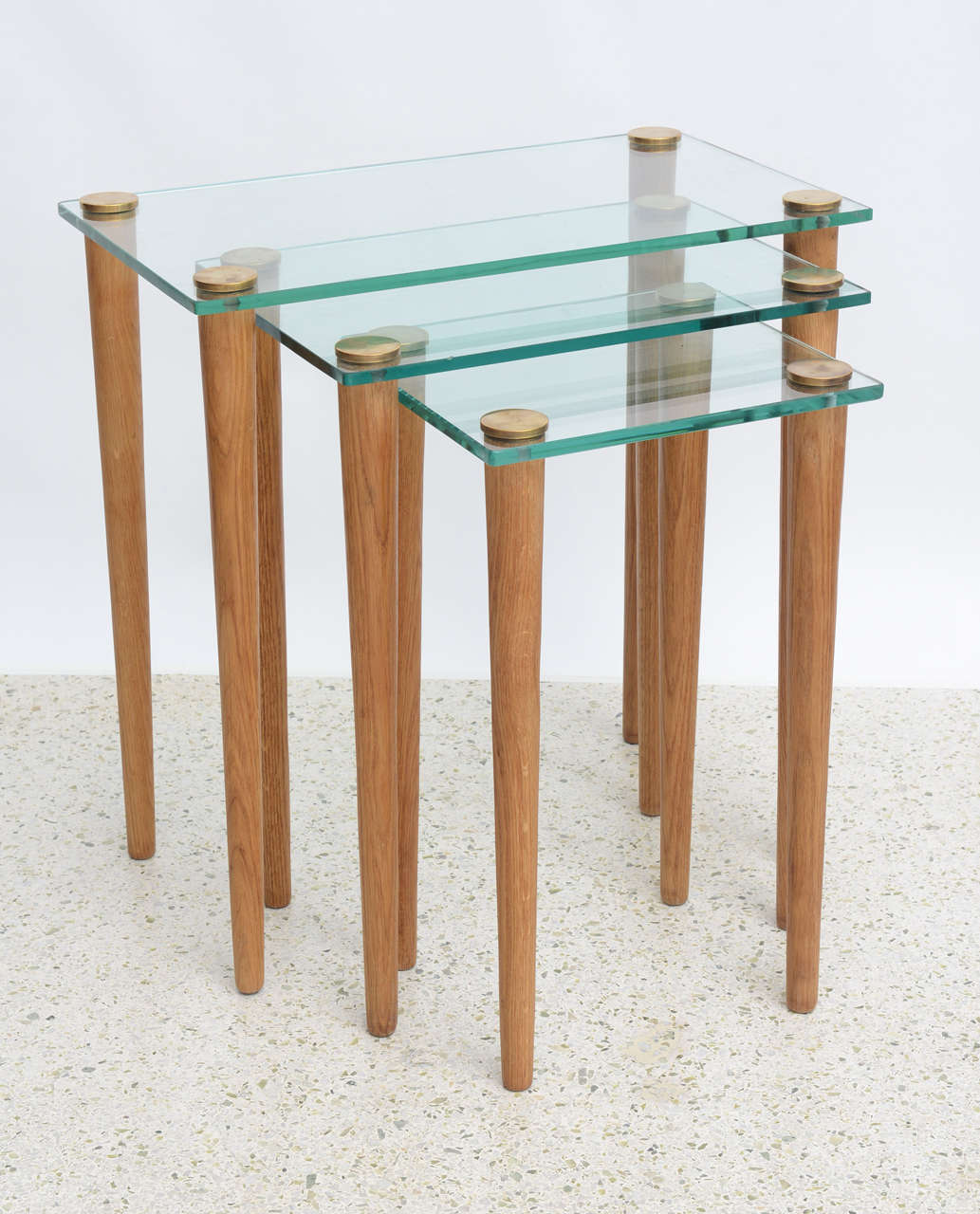 The glass tops with brass caps and round tapering legs.
Measures: Smallest table is 13.25” W x 11” D x 22” H.
Gilbert Rohde.