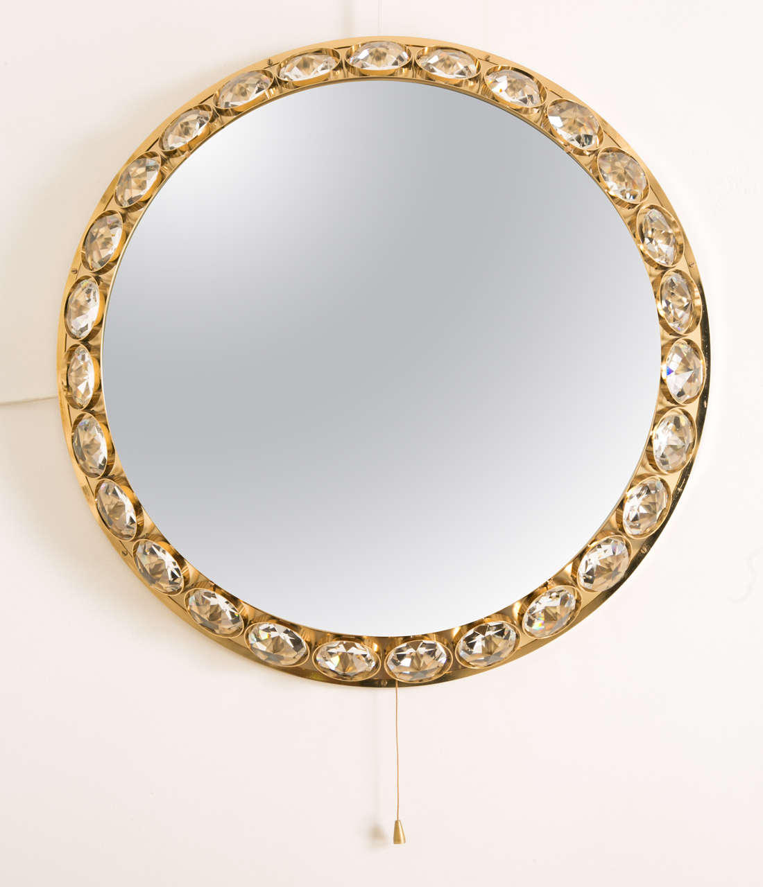 Spectacular circular lighting glass diamonds mirror by Bakalowits und Sohne, Austria, 1960s.
Ornated with 27 cut-glass diamonds; Refined double gilt brass structure.
Inside diameter 50 cm. Light bulbs into.
This is a typical mirror from this period