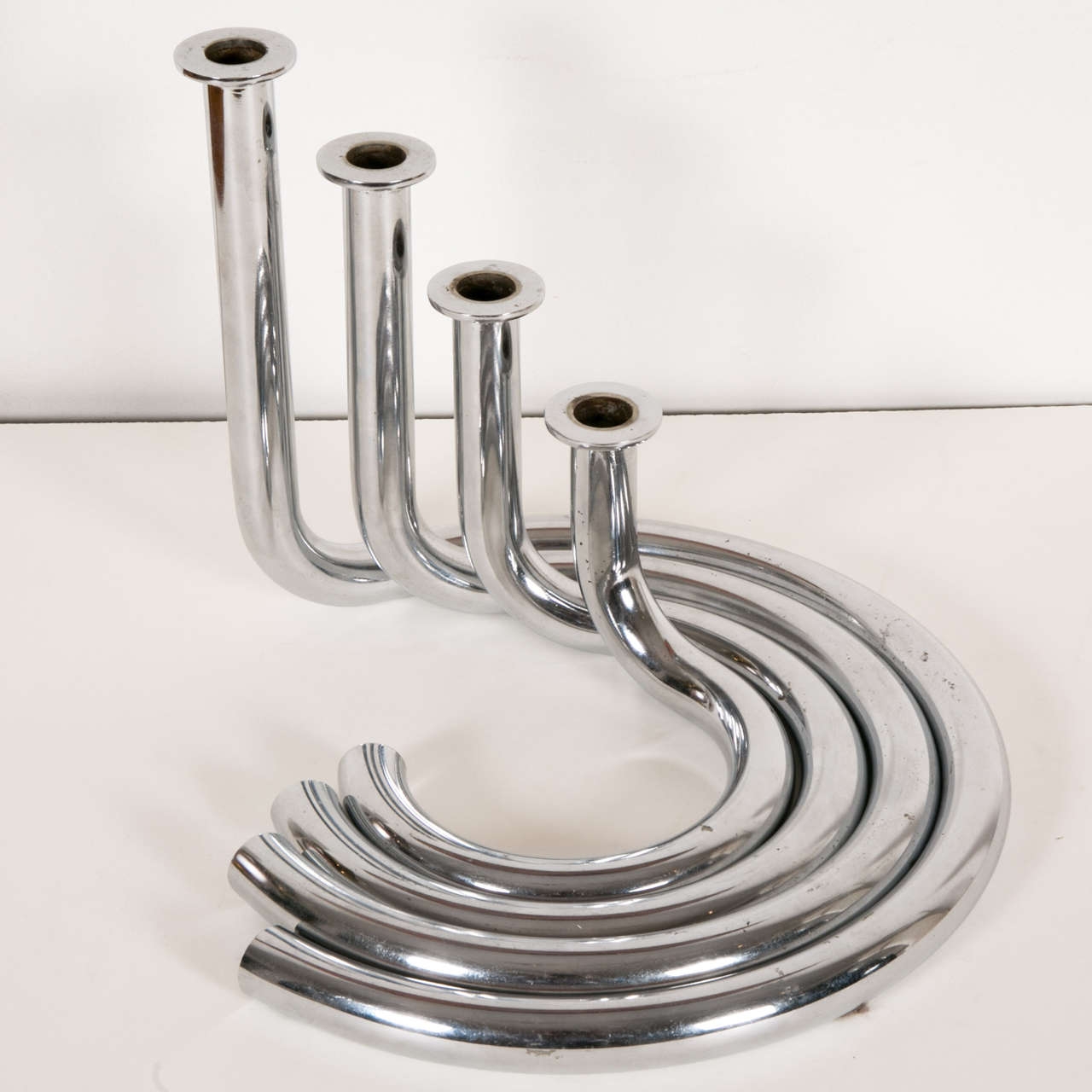 Interesting Chromed steel candleholder by Michel Boyer, 1972.
With four circular tubular removable bobeches.  

Michel BOYER (1935- 2011) interior and furniture designer, learned in the Paris Beaux Arts then at ENSAD where Arbus taught. He