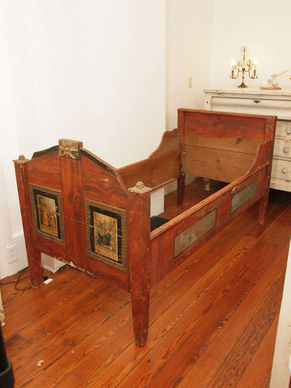 Perfect for a child due to its smaller scale (slightly shorter than a twin bed), this bed Italian convent bed is absolutely one of a kind.  Painted frame with gilded wood carvings and parchment print on frame. Gorgeous patina.  Due to its unique