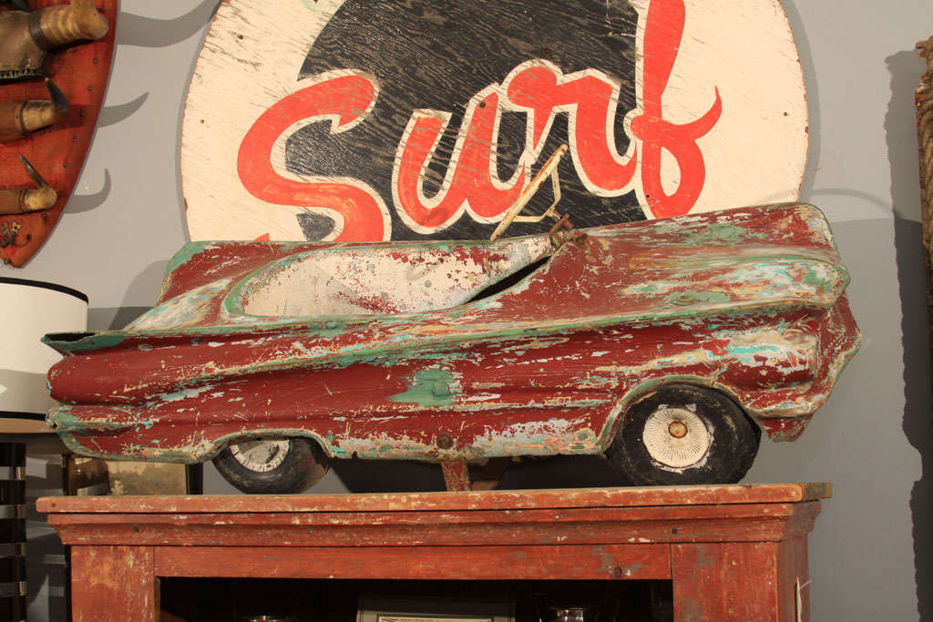 Very sweet molded resin carnival ride element in the over-stylized shape of an early 1960s convertible.   Lots of charm and cheer with this one;  red, white and green painted surfaces in a distressed patina overall.
