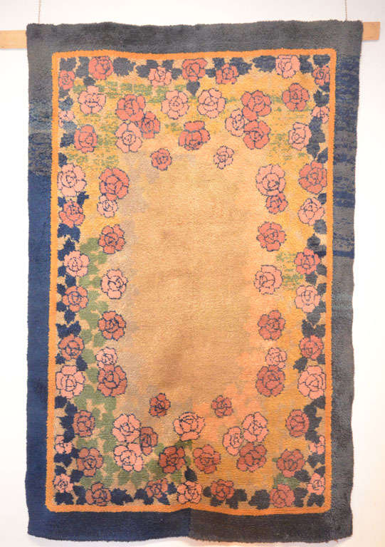 The floral spray of roses arranged around an oval open field is a style that is frequently encountered in the work of many French Art Deco artists, from Edouard Benedictus to Paul Poiret of Atelier Martine.
Although not signed, the present carpet