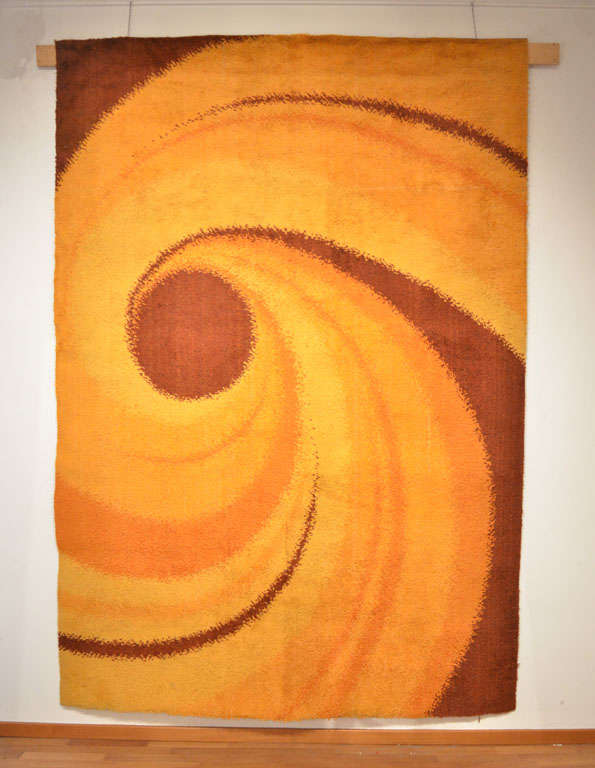 A whimsical Scandinavian carpet, characterized by a swirling centrifugal pattern of orange and brown shades typical of 1960 'Pop' design. An iconic piece that would fit perfectly a Mid-Century Modern interior with vintage 60's furniture.