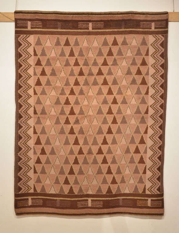 Woven in different tones of brown over a camel background, this Art Deco rug embodies the aesthetic of the period, juxtaposing an all-over pattern of triangles, probably taken from contemporaneous Moroccan rugs which were at their height of fashion,