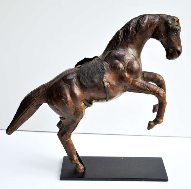 An early 20th century Argentinian Gaucho-crafted leather leaping horse, with skillfully rendered musculature and well-worn patina. Mounted on custom Stand.