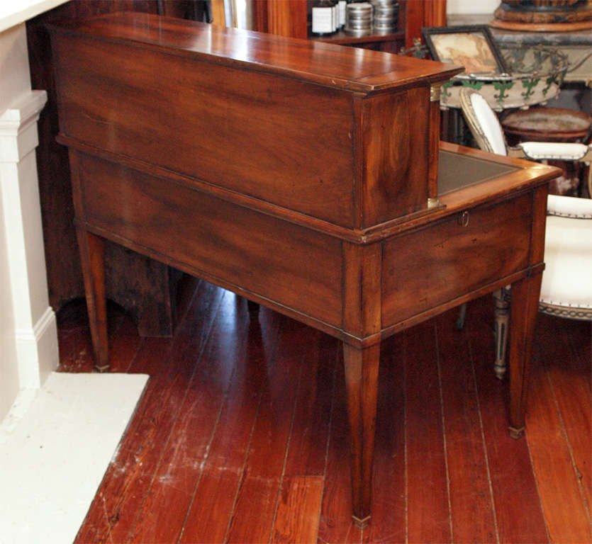 A fine quality bureau à gradin or writing table, with tapered legs and column flanked tier of small drawers and pigeonholes on the desktop surface.  There are five drawers under the work surface and pull-out writing surfaces on each side.