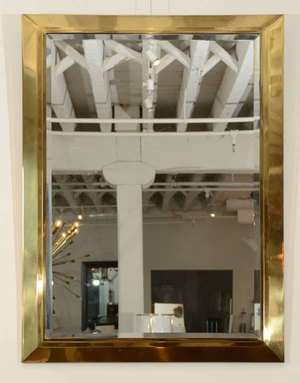 The plain brass mirror frame, supporting a bevel edged mirror.