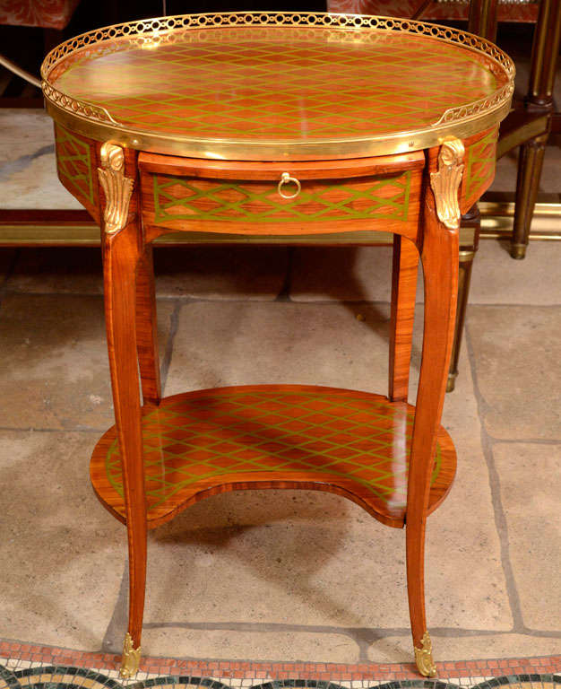 A Fine French Louis XV - XVI Transitional trellis inlaid oval side table with pierced bronze gallery, leather top writing slide, bronze mounts and shelf stretcher.