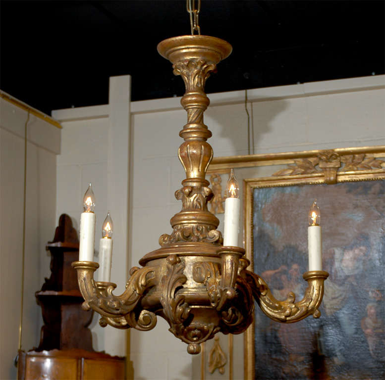 An Italian gilt-wood chandelier in the rococo style with 4 lights. Has recently been wired for U.S Electricity. 

William Word Fine Antiques: Atlanta's source for antique interiors since 1956. 