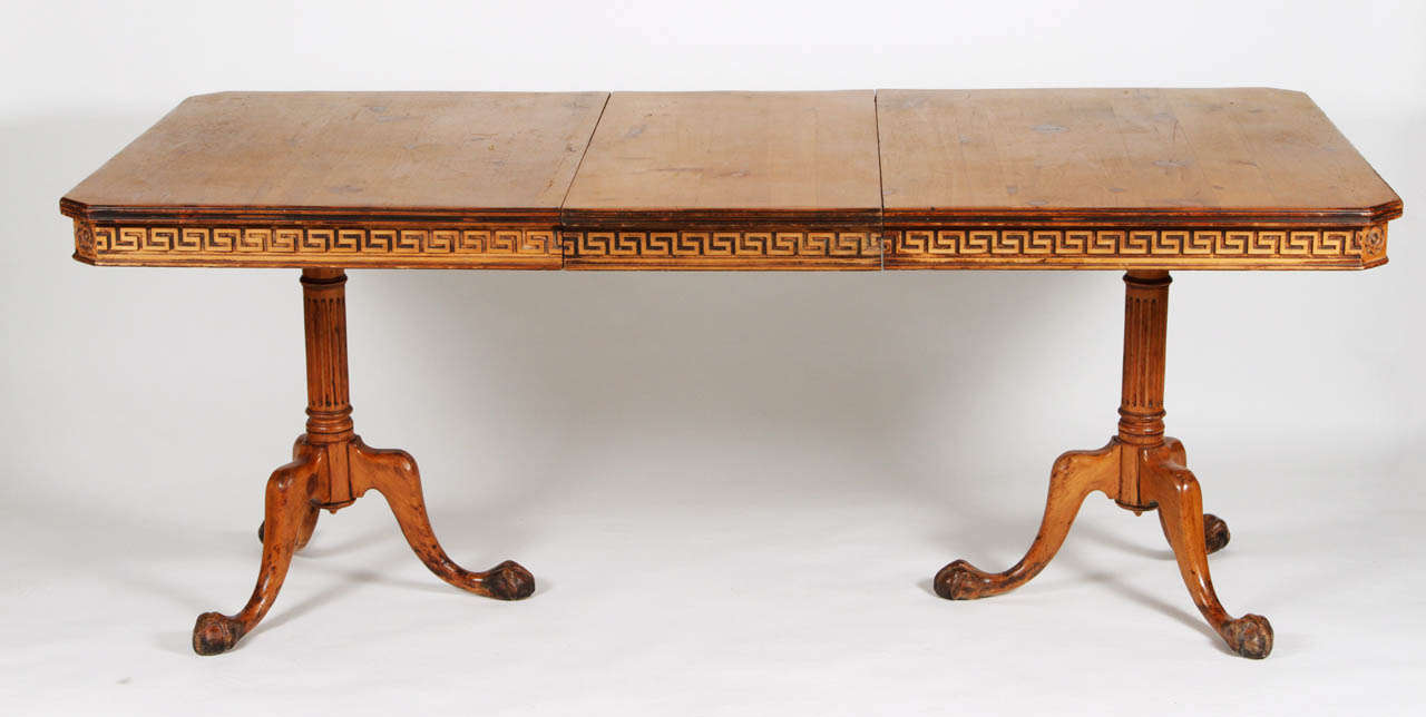 Solid pine table with single leaf extension. Greek key meander on apron with corner rosettes. Cylindrical pedestal bases have turned and fluted details with tripod legs terminating in claw-and-ball feet. English, circa 19th century.

DIMENSIONS: