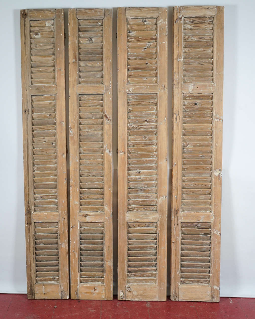 Wonderfully distressed vintage shutters with most of the paint already removed.  These shutters are well made with thick framing and stationary louvres.  The shutters have half the socket hinges attached to them.  Would make a fabulous