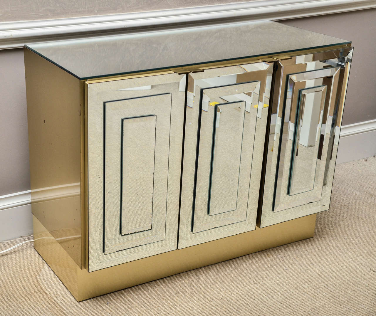 Attractive three-door mirrored buffet by Ello. The top and doors are mirrored. The sides and bottom are brass as are the door pulls.