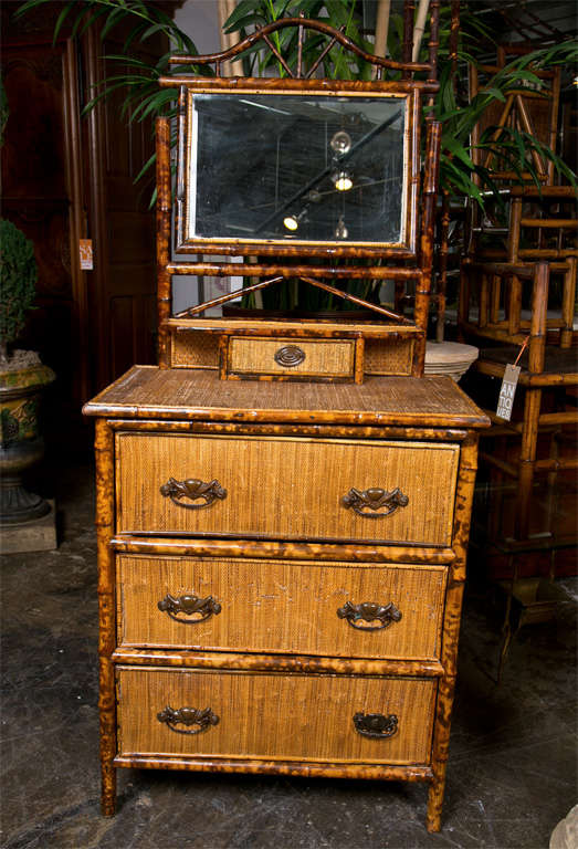 American bamboo and woven wicker chest, c. 1890, of three drawers with brass handles and a superstructure consisting of a jewelry drawer and a pivoting dressing mirror. From a Hampton's estate.