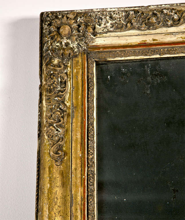French gilded mirror, mid 19th century, in the transitional Restauration/Louis Philippe style, with gesso molded flower decoration on all four corners