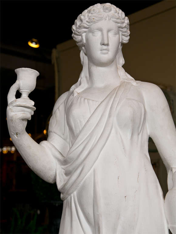 English plaster garden statue, 19th c., of a classical woman holding a vase and drinking goblet on a plinth